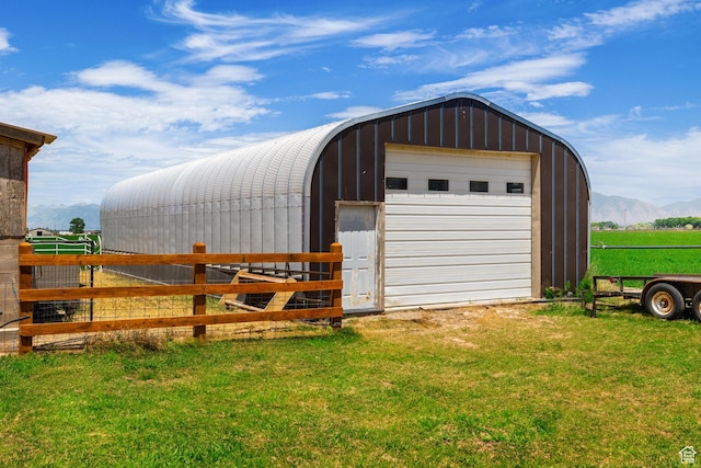 view of pole building with a lawn and fence
