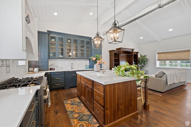 kitchen featuring a sink, light countertops, a kitchen breakfast bar, open floor plan, and gas range