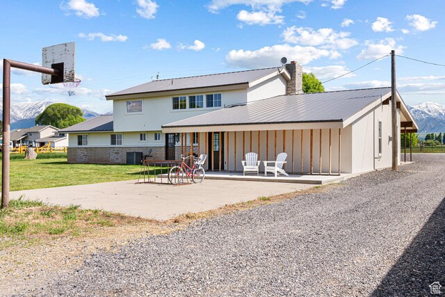 5186 W 9970 S, Payson, UT 84651 - back of house featuring a mountain view, metal roof, a patio area, central AC unit, and board and batten siding