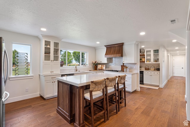 5186 W 9970 S, Payson, UT 84651 - kitchen with a sink, hardwood / wood-style floors, custom range hood, white cabinets, and a textured ceiling