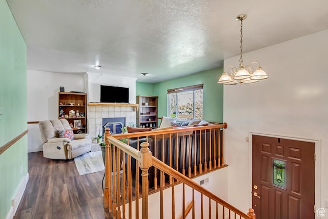 572 S Main St, Kaysville, UT 84037 - living room featuring dark wood-style floors, visible vents, baseboards, an inviting chandelier, and a tile fireplace