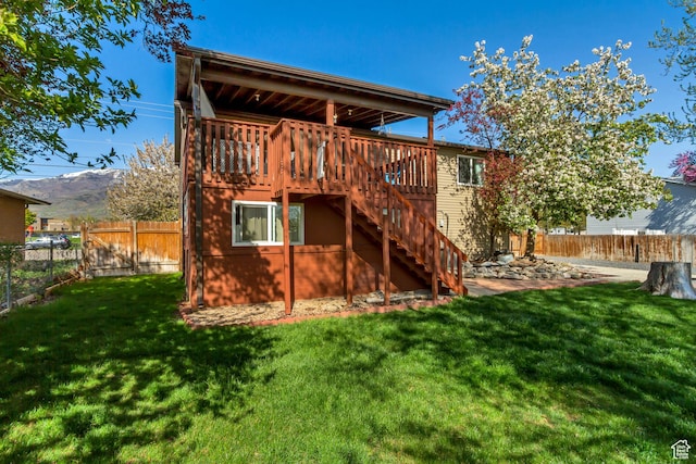572 S Main St, Kaysville, UT 84037 - rear view of property featuring a wooden deck, a yard, a fenced backyard, and stairway