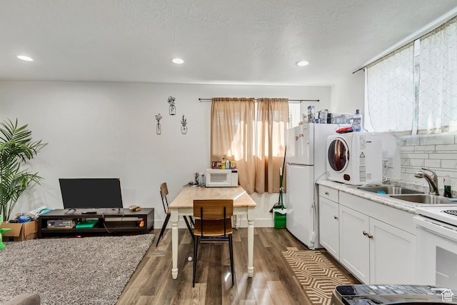 572 S Main St, Kaysville, UT 84037 - kitchen with tasteful backsplash, a sink, white appliances, white cabinetry, and dark wood-style floors