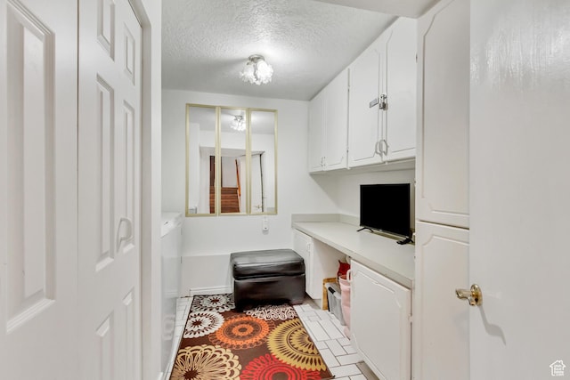 572 S Main St, Kaysville, UT 84037 - kitchen featuring a textured ceiling, light tile patterned flooring, white cabinetry, built in study area, and light countertops