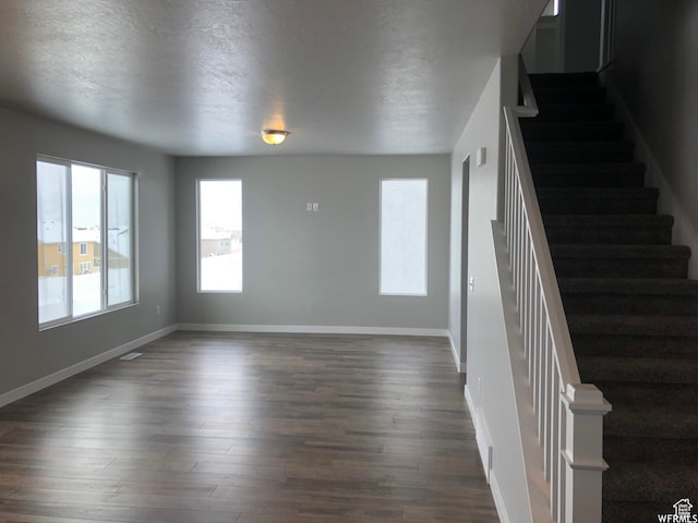 312 W Sapphire Dr, Tooele, UT 84074 - unfurnished living room featuring baseboards, dark wood-style flooring, and stairs