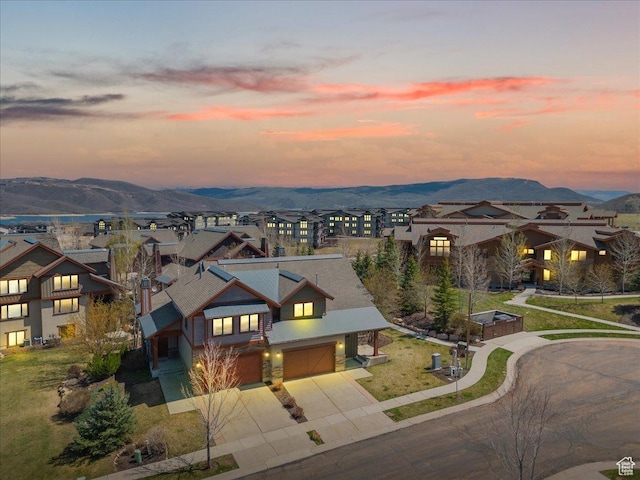 view of front of house featuring a garage, a residential view, driveway, and a mountain view
