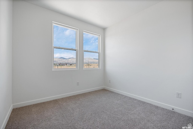 carpeted spare room with baseboards