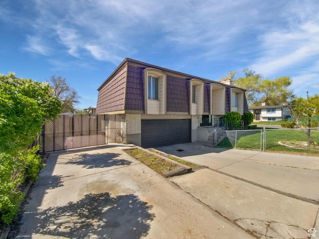 3445 W 3650 S, West Valley City, UT 84119 - split foyer home featuring concrete driveway, a gate, brick siding, and mansard roof