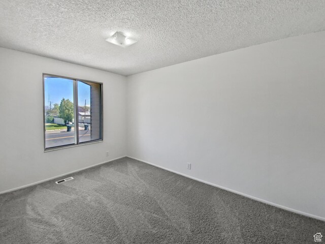 3445 W 3650 S, West Valley City, UT 84119 - empty room featuring baseboards, visible vents, dark carpet, and a textured ceiling