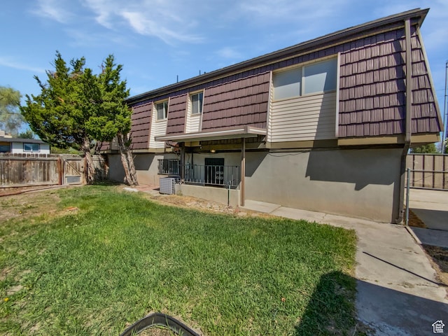 3445 W 3650 S, West Valley City, UT 84119 - rear view of house featuring stucco siding, a yard, mansard roof, and fence