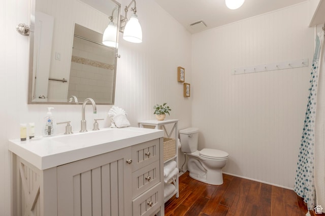 bathroom with visible vents, toilet, vanity, a shower with curtain, and hardwood / wood-style flooring