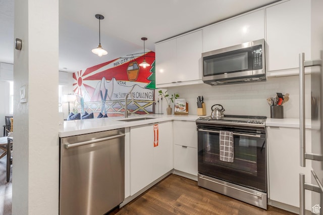 kitchen with a sink, white cabinetry, light countertops, decorative light fixtures, and appliances with stainless steel finishes