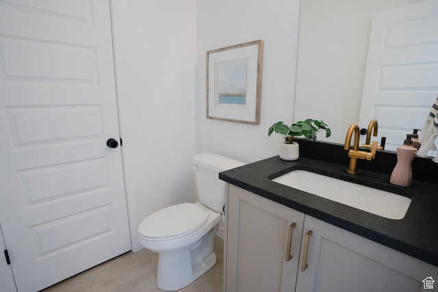 bathroom featuring tile patterned flooring, toilet, and vanity
