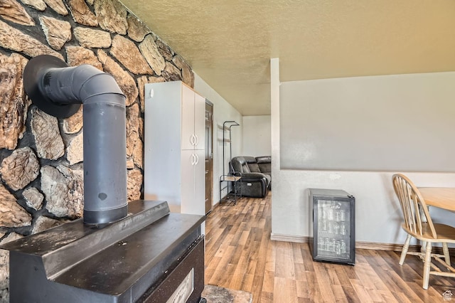 115 S 200 E, Cedar Fort, UT 84013 - interior space featuring baseboards, wood finished floors, a textured ceiling, and a wood stove