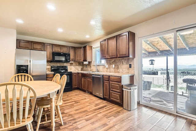 115 S 200 E, Cedar Fort, UT 84013 - kitchen with light wood finished floors, a sink, backsplash, light countertops, and black appliances