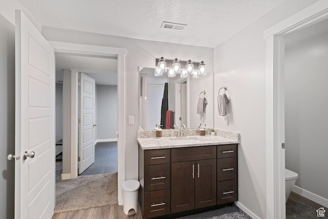 2414 N 4060 W, Lehi, UT 84043 - bathroom featuring toilet, wood finished floors, vanity, baseboards, and visible vents