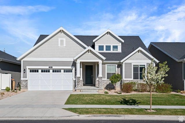 craftsman house featuring an attached garage, stone siding, a front yard, and concrete driveway