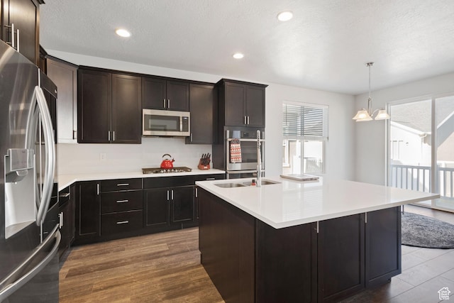 2414 N 4060 W, Lehi, UT 84043 - kitchen with stainless steel appliances, light countertops, a sink, decorative light fixtures, and a center island with sink
