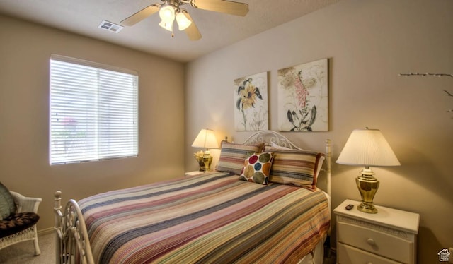 carpeted bedroom with visible vents, a ceiling fan, and multiple windows