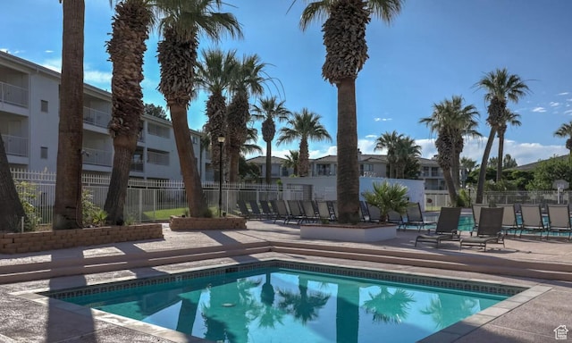 community pool with fence and a patio area