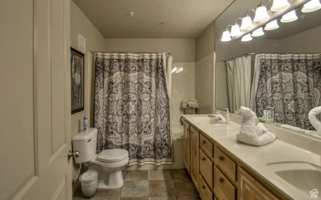 bathroom with tile patterned flooring, a sink, double vanity, and toilet