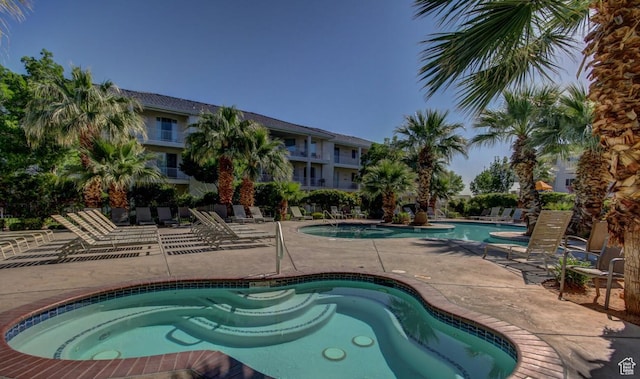 community pool featuring a community hot tub and a patio area