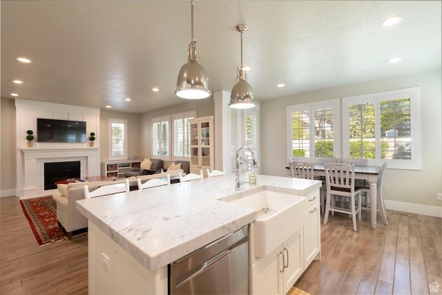 kitchen featuring light wood finished floors, a sink, baseboards, recessed lighting, and dishwasher
