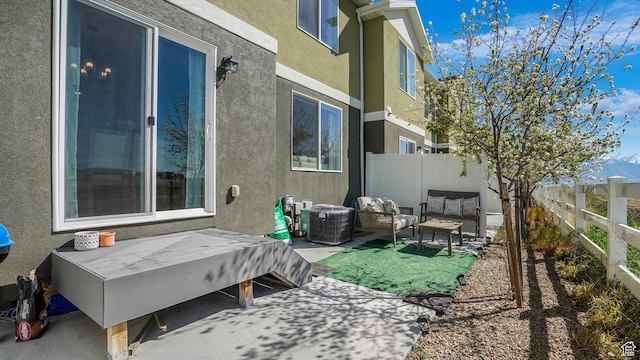 exterior space featuring an outdoor living space, a fenced backyard, a patio, cooling unit, and stucco siding