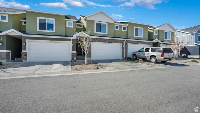 multi unit property with a residential view, an attached garage, stucco siding, and driveway
