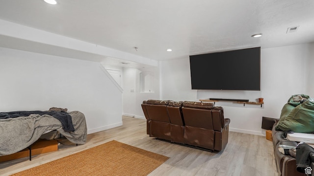 cinema room with visible vents, light wood finished floors, and baseboards