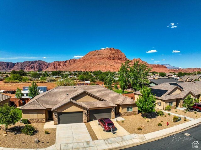232 W 200 S, Ivins, UT 84738 - view of front of property with concrete driveway, an attached garage, stucco siding, stone siding, and a mountain view
