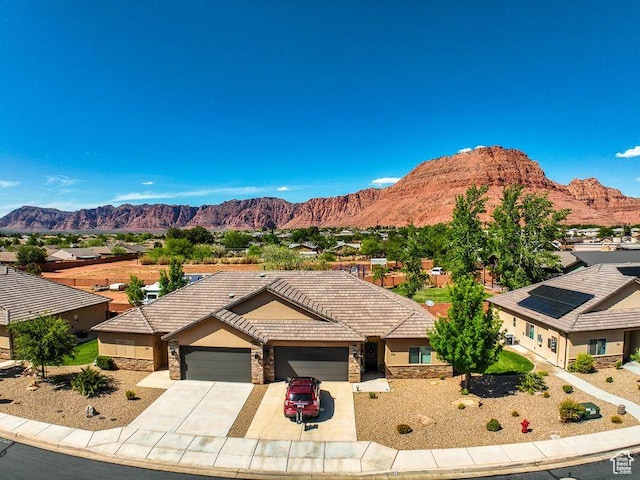 232 W 200 S, Ivins, UT 84738 - view of front of home with stone siding, a mountain view, and a garage