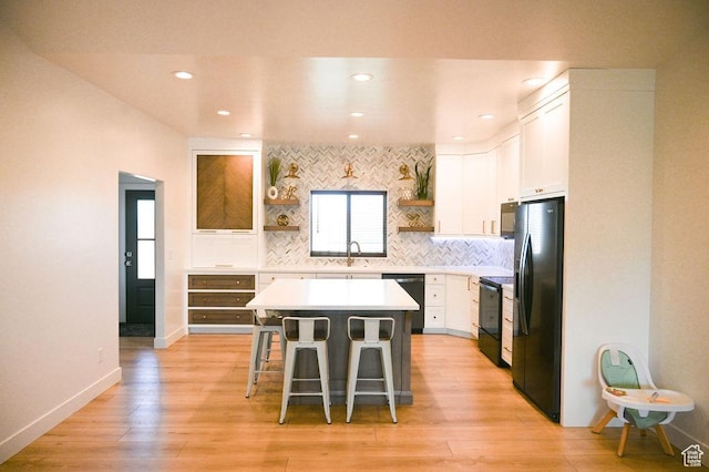 2167 S 560 W, Roosevelt, UT 84066 - kitchen featuring open shelves, a sink, black appliances, a breakfast bar area, and white cabinetry