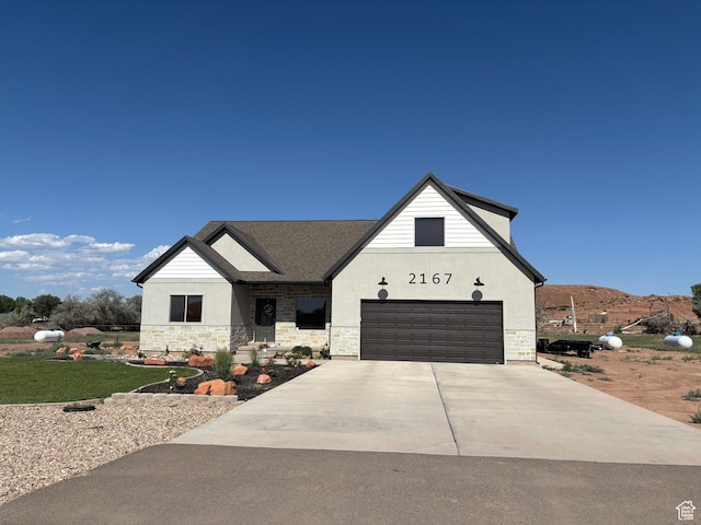 2167 S 560 W, Roosevelt, UT 84066 - view of front of property with stucco siding, stone siding, concrete driveway, and an attached garage
