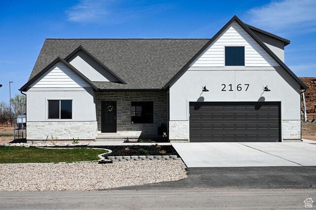 modern inspired farmhouse featuring stucco siding, roof with shingles, stone siding, and concrete driveway