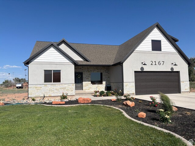 2167 S 560 W, Roosevelt, UT 84066 - view of front of house with stone siding, driveway, a front lawn, and a shingled roof