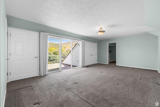 unfurnished bedroom with baseboards, carpet flooring, access to outside, and a textured ceiling