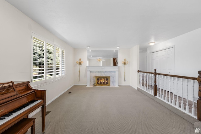 carpeted living room featuring a premium fireplace and baseboards