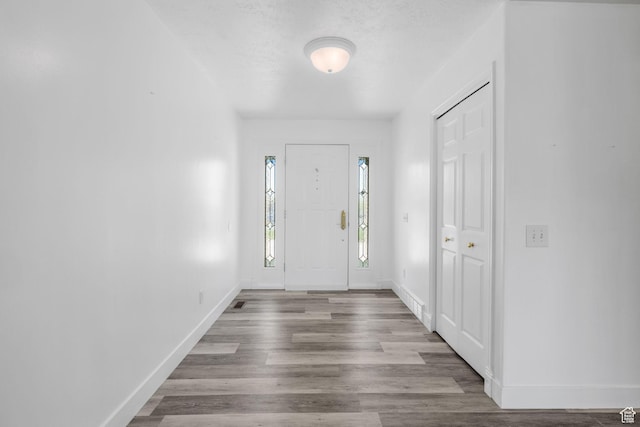 foyer entrance with wood finished floors and baseboards