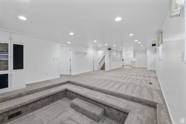 below grade area featuring stairway, baseboards, recessed lighting, and carpet