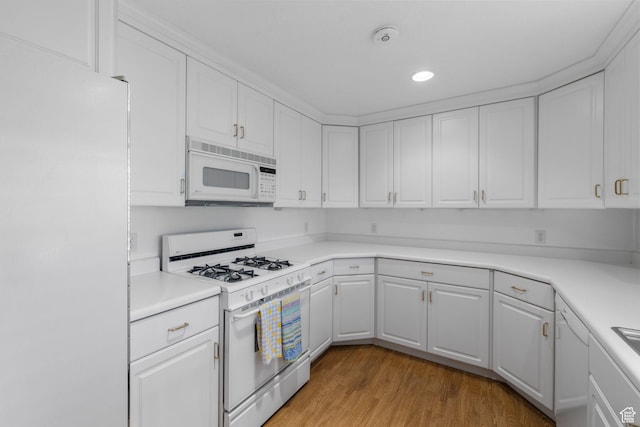 kitchen with light countertops, light wood-style flooring, white cabinetry, and white appliances