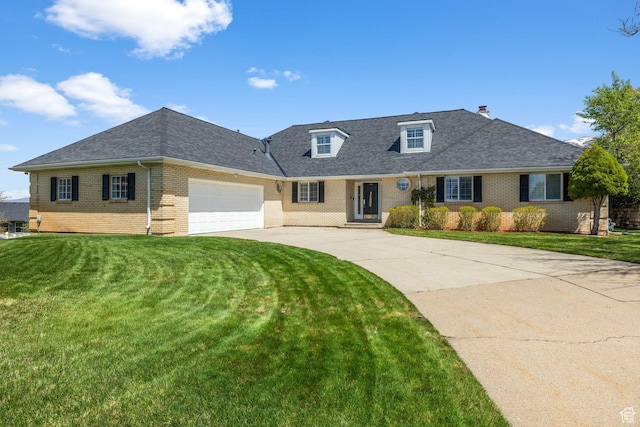 view of front of house featuring an attached garage, brick siding, a front yard, and concrete driveway