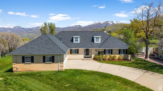 traditional-style home with brick siding, concrete driveway, and a mountain view