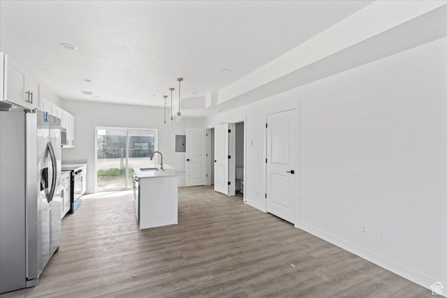 805 S 800 W Unit A, Salt Lake City, UT 84104 - kitchen with an island with sink, light countertops, wood finished floors, stainless steel fridge, and white cabinetry