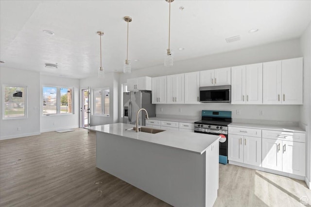 805 S 800 W Unit A, Salt Lake City, UT 84104 - kitchen with stainless steel appliances, a sink, light wood-style floors, and white cabinetry