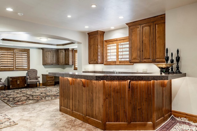 3143 E Bavarian Ct, Cottonwood Heights, UT 84093 - kitchen with dark countertops, baseboards, a kitchen bar, a peninsula, and recessed lighting