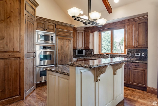 3143 E Bavarian Ct, Cottonwood Heights, UT 84093 - kitchen featuring light wood finished floors, a center island, an inviting chandelier, backsplash, and built in appliances