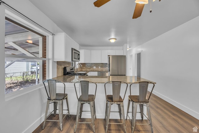 181 E 4300 S, Washington Terrace, UT 84405 - kitchen with stainless steel appliances, stone counters, baseboards, a peninsula, and white cabinetry