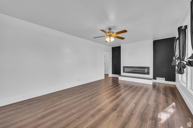 181 E 4300 S, Washington Terrace, UT 84405 - unfurnished living room featuring heating unit, visible vents, a ceiling fan, dark wood-type flooring, and baseboards