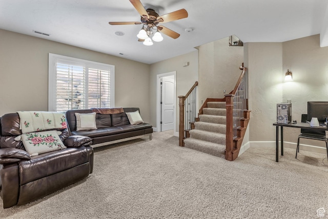 living area featuring baseboards, visible vents, carpet flooring, and ceiling fan